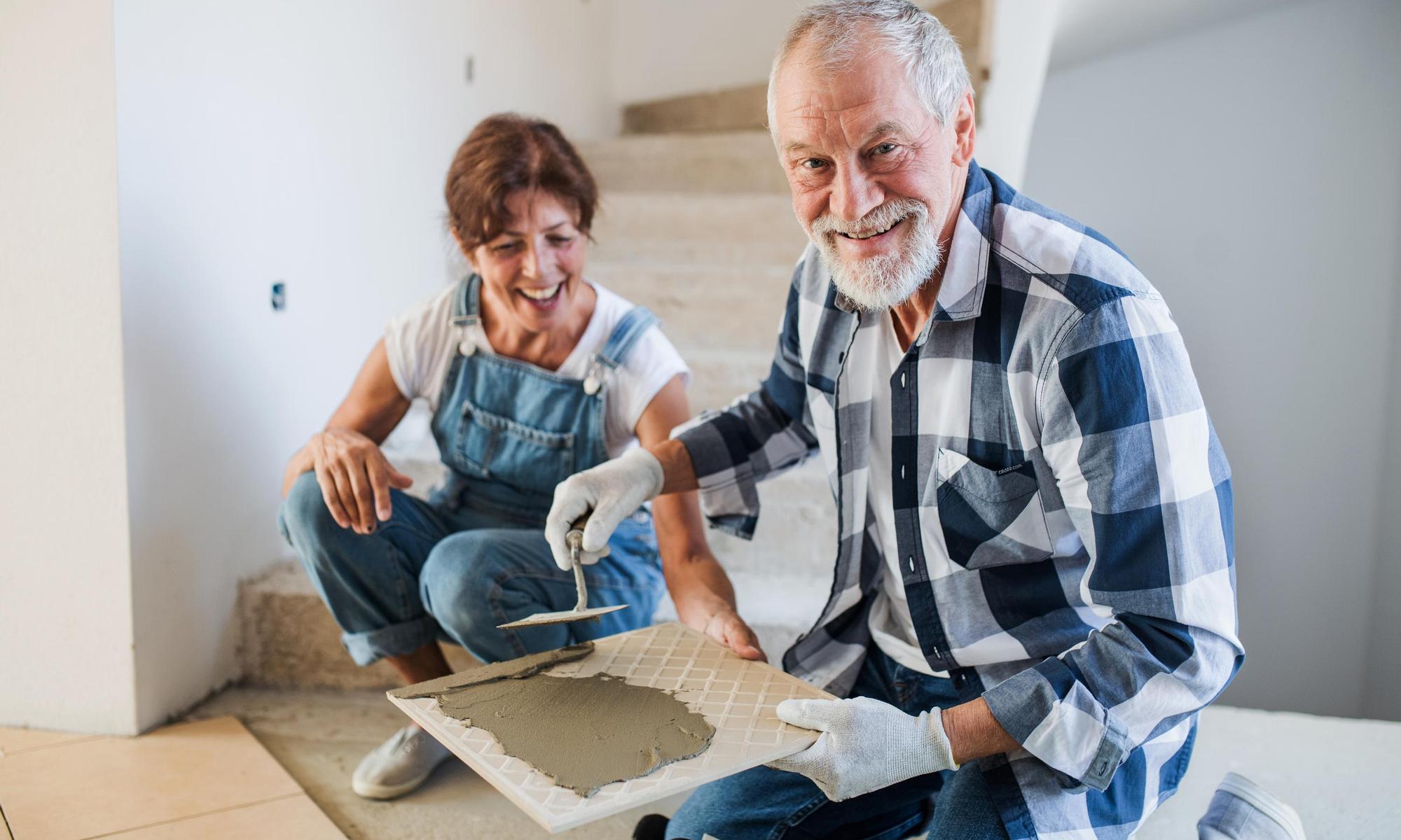 Old man and woman working on interior of new house or flat.